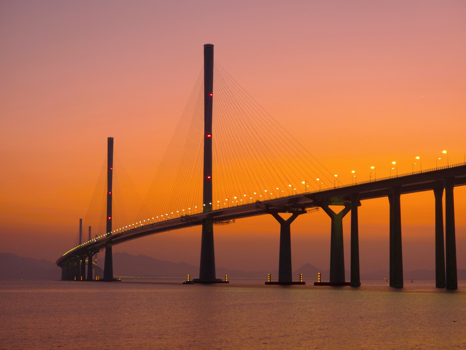 An illuminated bridge extending across the water